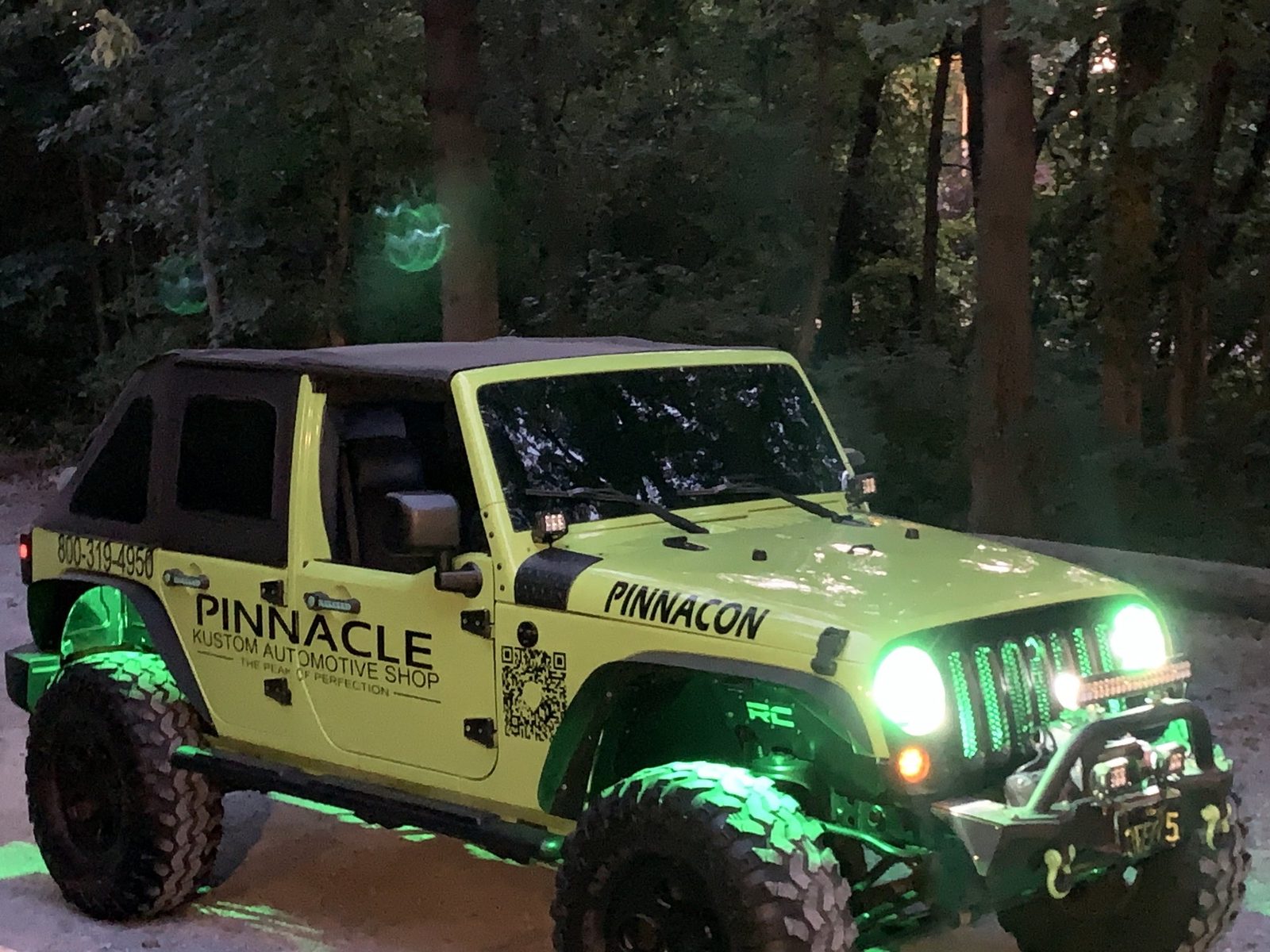 The Pinnacle Jeep at night with green underbody lighting, illuminated grille and halo headlights
