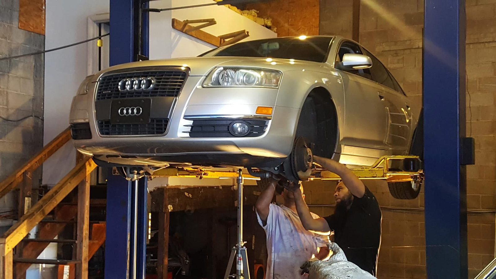 A sedan raised on a two-post lift for steering and underbody service at Pinnacle.