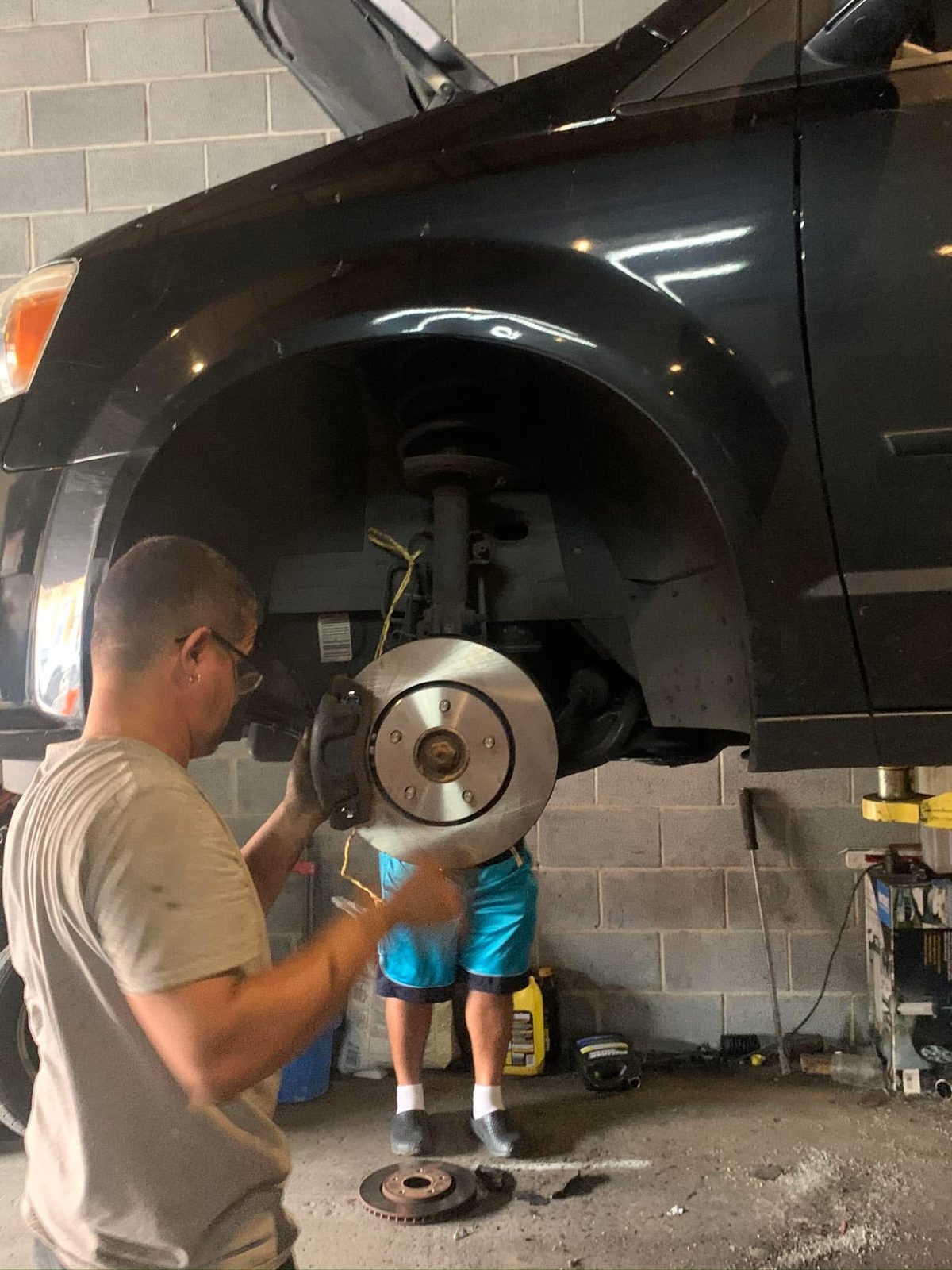 A technician fitting a brake rotor during brake service on an SUV at Pinnacle.
