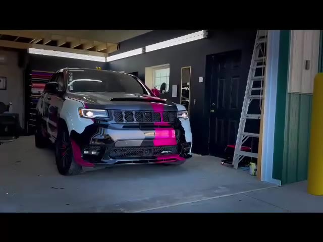 Jeep Grand Cherokee in a custom camo-pattern vinyl wrap, in the shop